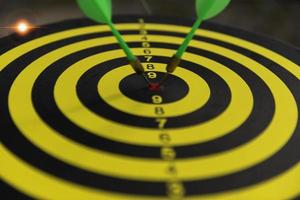 Two dart hit it's target on a red background, concept for success,darts motion blur. photo