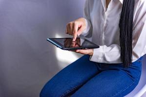 A close-up picture of a young business woman using a tablet computer to find financial information. photo