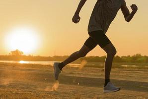 pies de corredor corriendo en primer plano de carretera en el zapato. hombre fitness sunrise jog entrenamiento bienestar concepto.