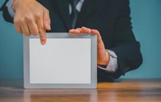 Business man holding and pointing on digital tablet on the desk with isolated white background and copy space. photo