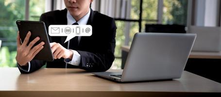 Business people hands texting on mobile phone, tablet computer with communication contact icon, E-mail, Phone number, Social media chatting message. photo