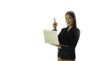 Young Asian business woman holding laptop computer and pointing hand up isolated on white background. photo