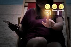 Finger of woman touching and check mark on smile satisfaction rating icon face. photo