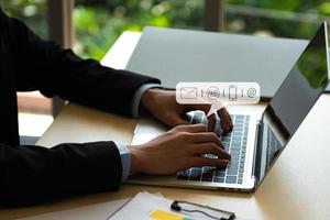 concepto de contacto comercial, manos escribiendo en la computadora del teclado con icono de contacto de comunicación, correo electrónico, número de teléfono, mensaje de chat en las redes sociales. foto