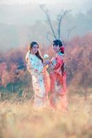 Travel and vacation in Japan concept, Two Young Asian woman wearing traditional Japanese kimono and hands holding beautiful white rose, Japan. photo