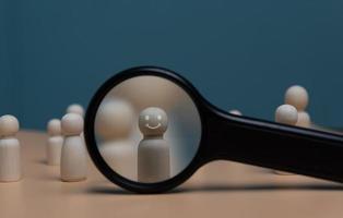 HRM or Human Resource Management, Magnifier glass focus to manager icon which is among staff icons for human development recruitment leadership and customer target group concept. photo