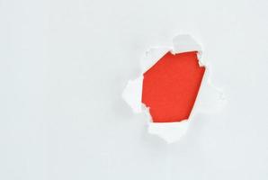 Ripped white paper against a red background photo