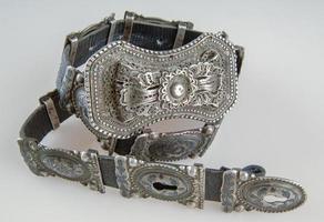 An antique, silver belt isolated on a white background, close-up photo