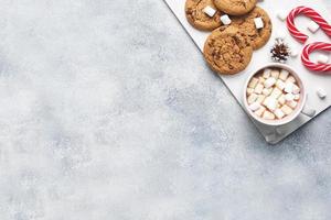 The chocolate chip cookie, Christmas cane caramel Cup cocoa and marshmallow cones Decorations on a gray background. Copy space Frame. photo