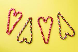 Christmas caramel canes on a yellow background. Holiday festive celebration greeting card with copy space to adding text. photo