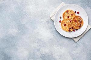 Cottage cheese pancakes with cranberries. Russian syrniki or sirniki, cottage cheese fritters or pancakes on the plate. photo