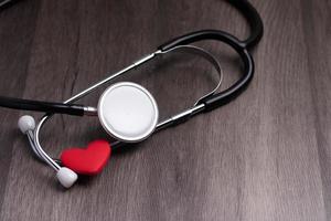 Stethoscope with red heart on gray background. Heart health care concept. photo