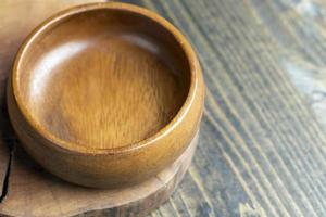 cuenco de madera sobre mesa de madera, cuenco redondo vacío para comestibles y comida foto