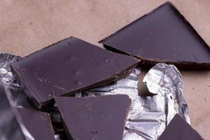 A broken chocolate bar in a paper and foil package photo