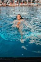 joven nadadora en el agua de la piscina azul foto