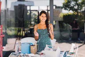 Young beautiful female artist with tools posing for camera photo