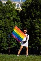 mujer joven sosteniendo una bandera del orgullo lgbt en sus manos. foto