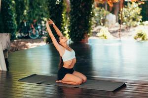 mujer joven practicando yoga. realiza un ejercicio foto