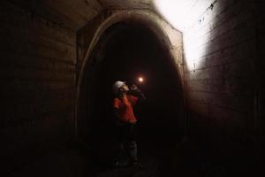 Female digger with flashlight explores the tunnel photo