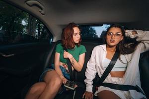 Friends together in the back seat of a taxi photo