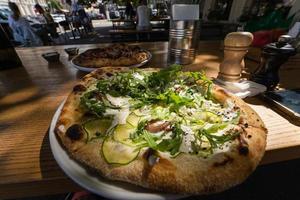 pequeña pizza vegetariana en una mesa en un café de la calle foto