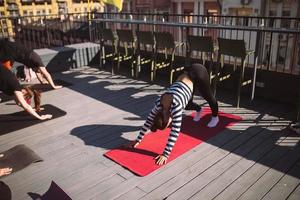 Yogi woman and diverse group of sporty people practicing yoga photo