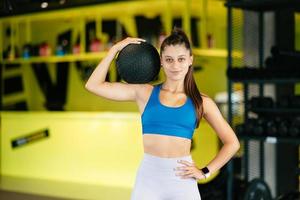 Young woman doing exercises with ball at the gym photo