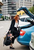 A woman puts things in the car photo