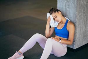 Healthy young female sitting relaxed after training in gym. photo