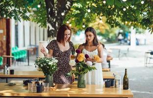 dos mujeres jóvenes componen un hermoso ramo festivo. foto