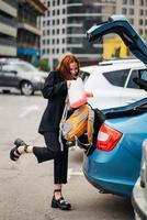 A woman puts things in the car photo