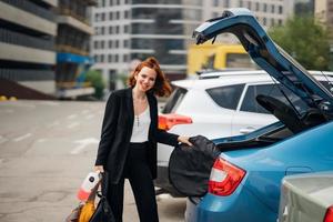 una mujer pone cosas en el auto foto