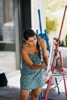 Young woman artist paints with a spatula on the canvas photo