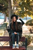 Young woman on a bench in the autumn park photo