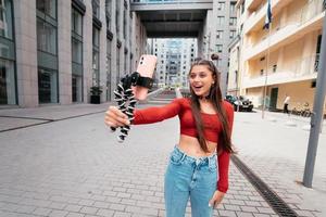 Young female blogger with smartphone streaming on the street. photo