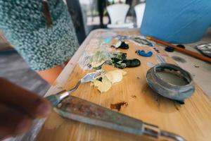 Close up of woman's hand mix paints in palette photo