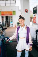 Woman filling her car with fuel at a gas station