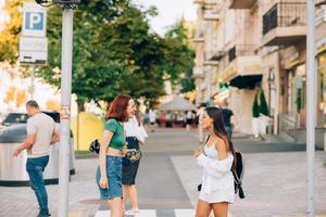 mujeres felices hablando y riéndose de la calle de la ciudad foto