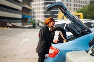 una mujer pone cosas en el auto foto