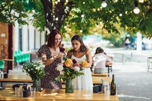 dos mujeres jóvenes componen un hermoso ramo festivo. foto