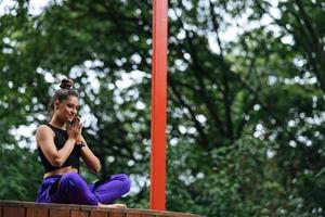 Young woman is practising yoga sitting in the lotus position photo
