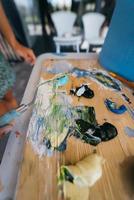 primer plano de la mano de la mujer mezclar pinturas en la paleta foto