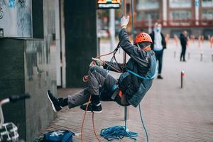 Industrial climber in uniform and helmet rises photo