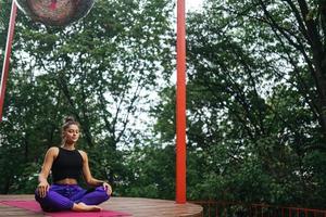 Young woman is practising yoga sitting in the lotus position photo