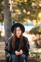 Young woman on a bench in the autumn park photo