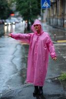 Young girl trying to stop a cab. Woman calling a taxi on a rainy day. photo