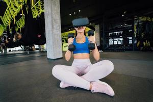 Woman wearing glasses of the virtual reality exercising with dumbbells photo