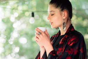 Shot of young woman drinking from tea bowl photo