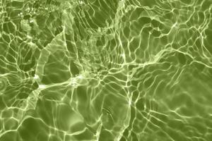 Defocus blurred transparent green colored clear calm water surface texture with splashes and bubbles. Trendy abstract nature background. Water waves in sunlight with copy space. Green watercolor shine photo