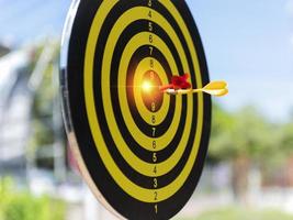 Two dart hit it's target on a red background, concept for success,darts motion blur. photo